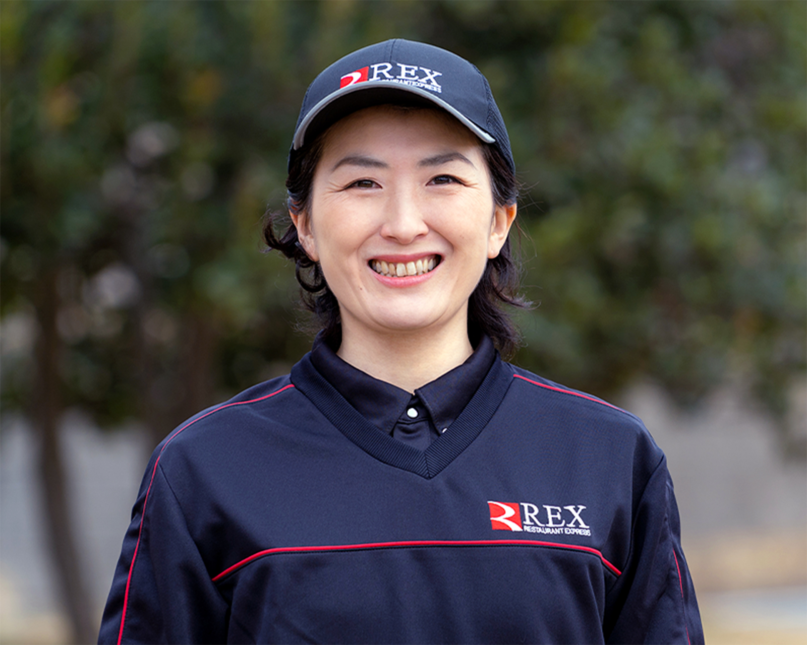 屋外で笑顔を見せるデリバリースタッフ