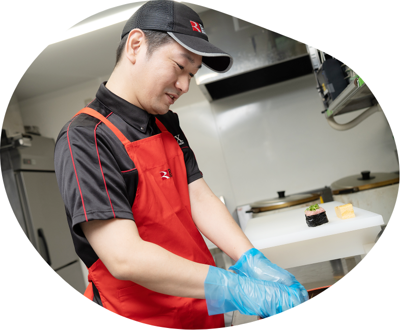 調理場で盛り付け作業をするスタッフのTさん