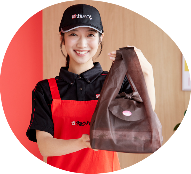 笑顔で商品を渡すスタッフのYさん
