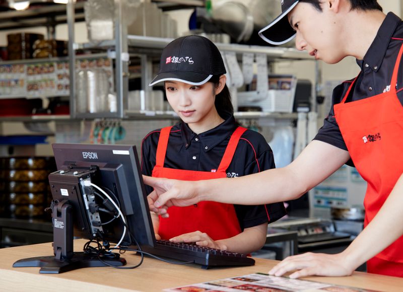 店舗で先輩スタッフと作業をするYさん