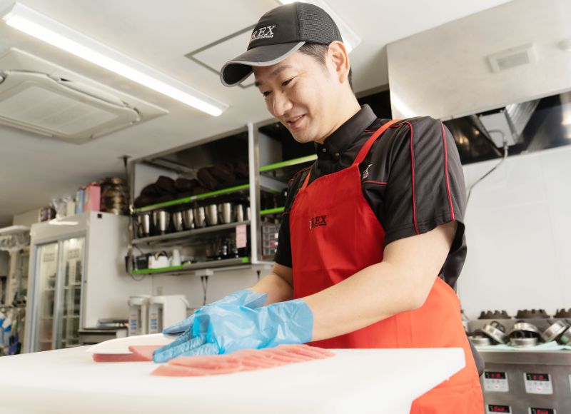 厨房で調理作業をするTさん