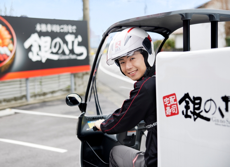 配達用バイクに乗り配達に向かおうとしているKさん