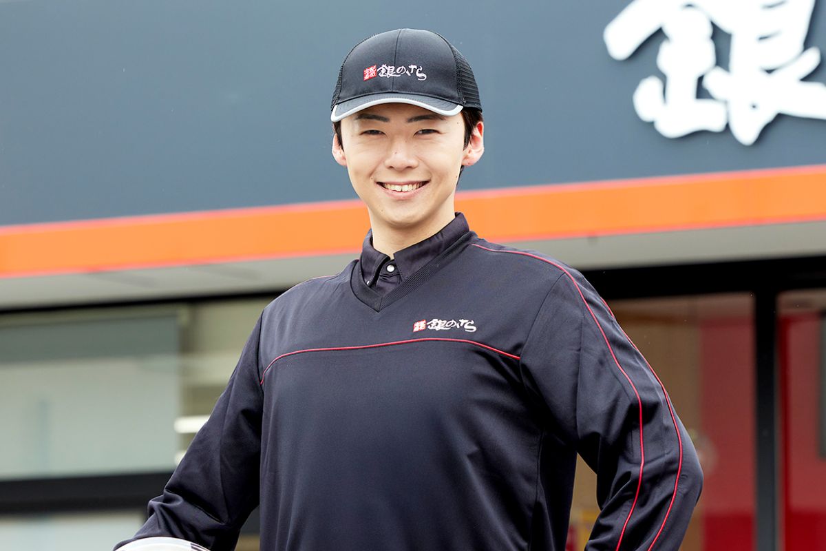 店舗前で笑顔を見せるKさん