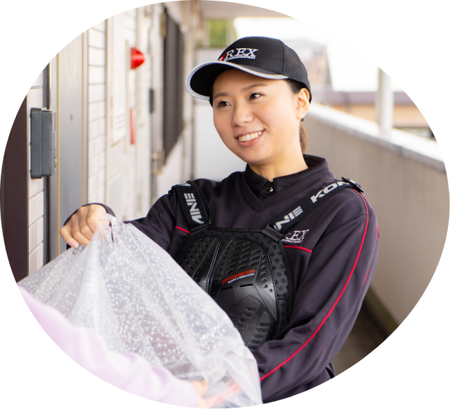 袋に入った商品を手渡しするスタッフのSさん