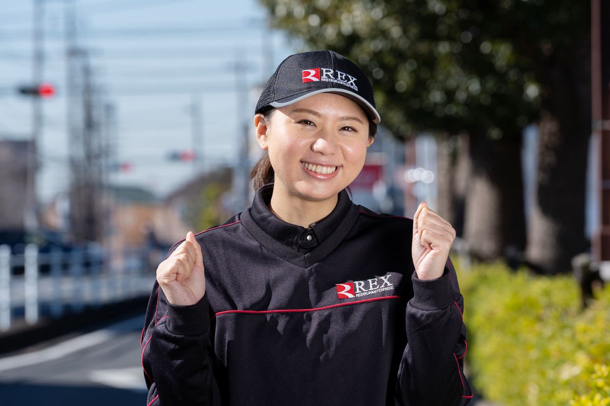 店舗前で笑顔を見せるSさん